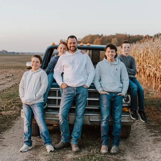 The Steenholl family in front of their pickup truck at the farm
