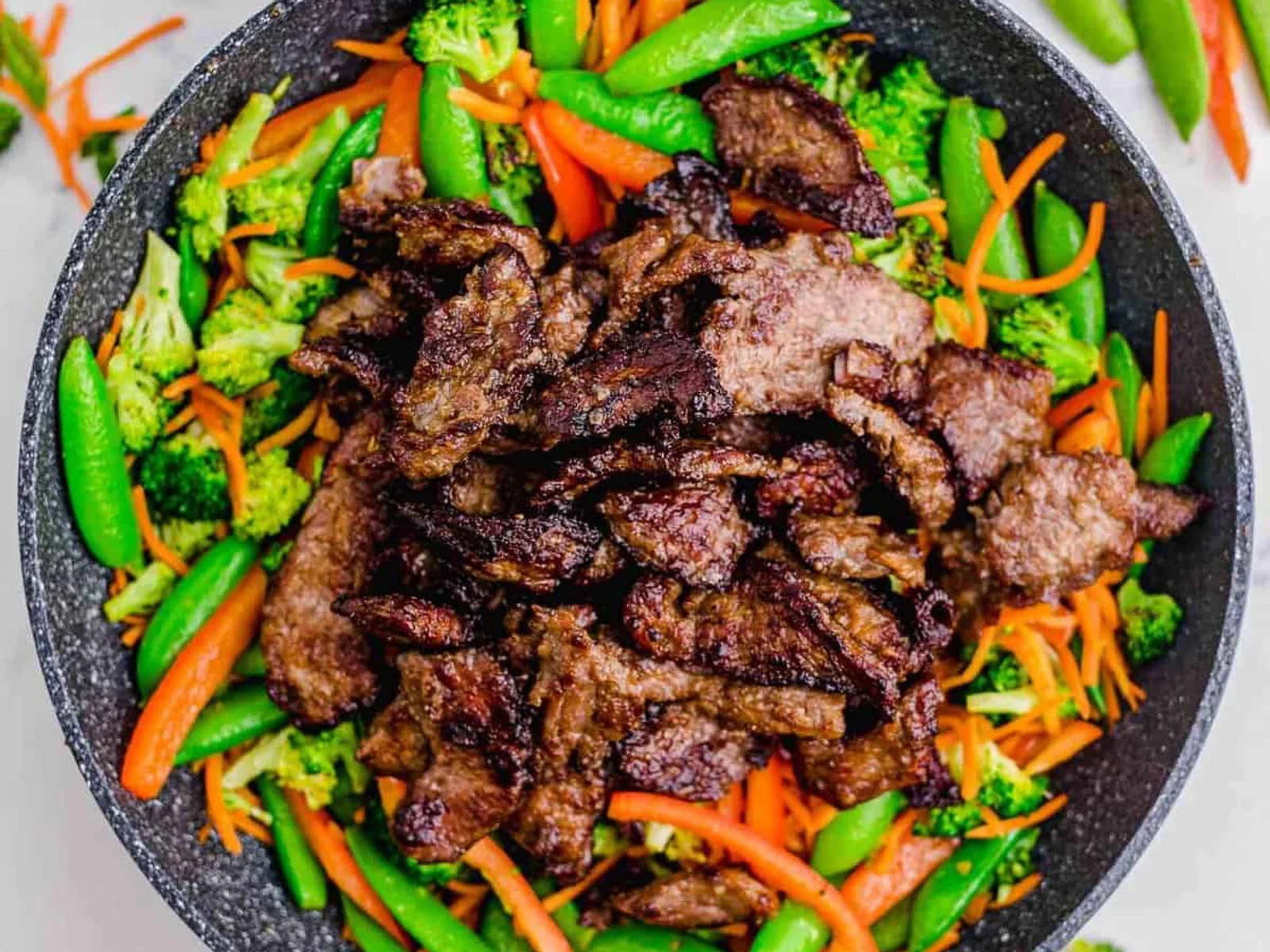 Beef stir fry strips with peppers and broccoli in a pan