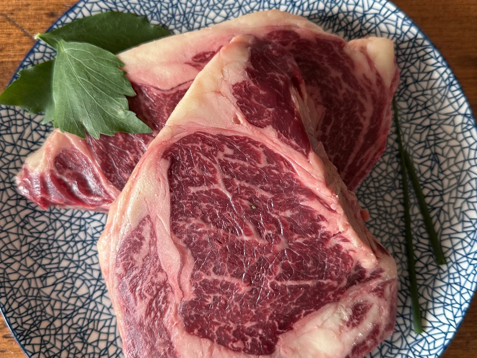 Rib eye steak plated with bay leaf and green beans